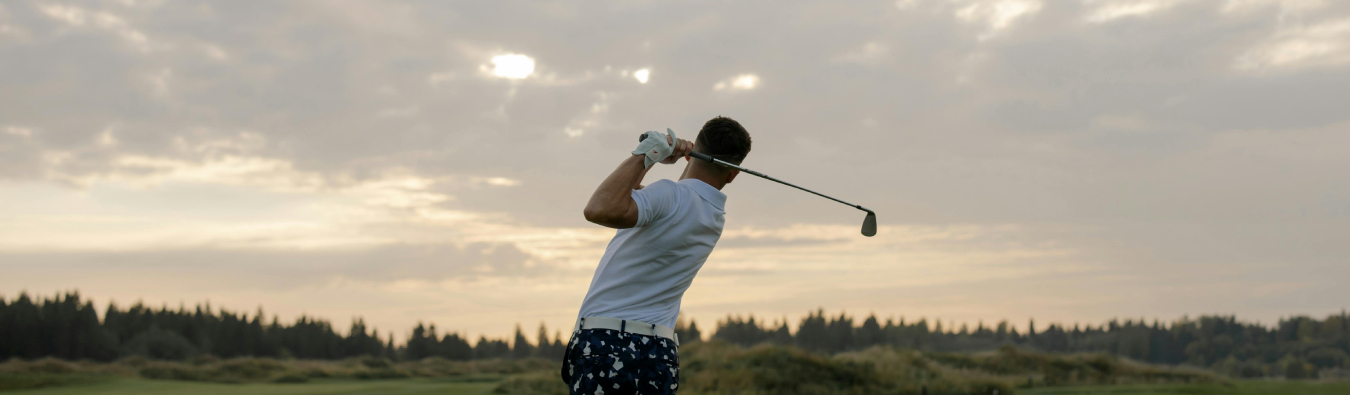 Male golfer in mid-swing on a golf course at sunset, symbolizing elite athletic performance and global ambition – banner image for Hogan Lovells and GSE Worldwide case study